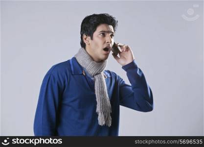 Surprised man having conversation on mobile phone