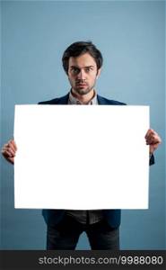 Surprised man holding white advertising banner.Surprised man with empty advertising banner. Man holds board for advertising. Handsome man with sign board. Space for text. Advertising. Black friday.. Surprised man holding white advertising banner