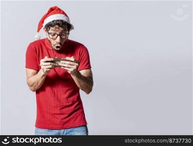 Surprised people watching a christmas promotion on the phone. Amazed man looking at a christmas offer online, Guy looking at a christmas promo on phone. Online christmas special offers concept