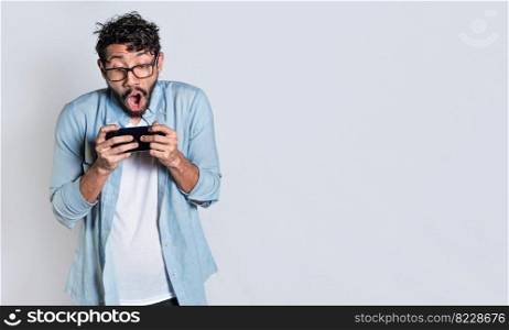 Surprised people watching an advertisement on their cell phone. Amazed man holding cell phone horizontally on isolated background, Person gasping and playing games on his mobile