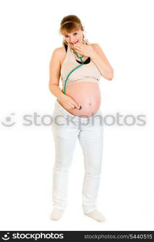 Surprised pregnant female holding stethoscope on her tummy isolated on white&#xA;