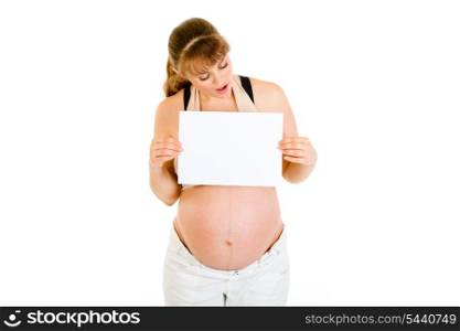Surprised pregnant woman looking on empty white paper isolated on white&#xA;
