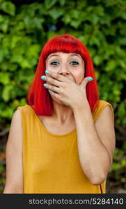Surprised red haired woman in a park wearing yellow dress