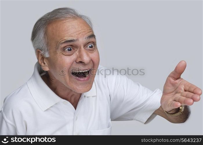 Surprised senior man over gray background