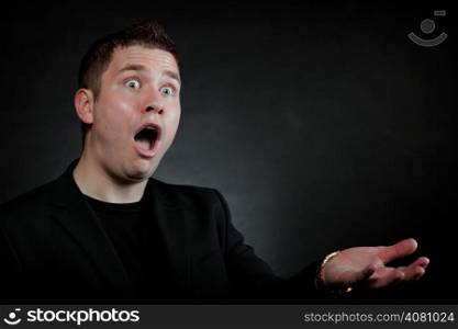 surprised shocked man face hand gesture wide eyed black background
