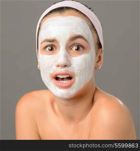 Surprised teenage girl looking camera face mask on gray background