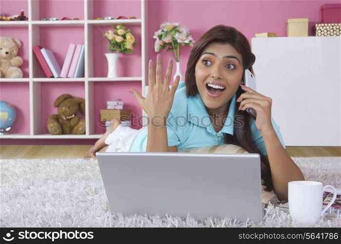 Surprised woman answering mobile phone at home