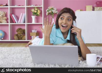 Surprised woman answering mobile phone at home