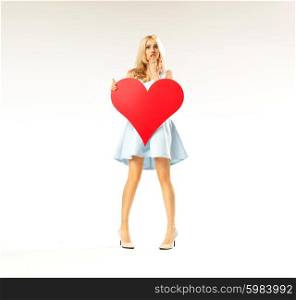 Surprised woman holding a huge heart