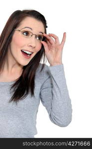 Surprised woman holding her glasses