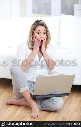 Surprised woman in front of laptop computer