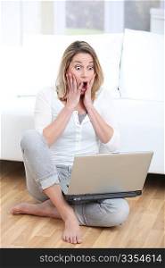 Surprised woman in front of laptop computer