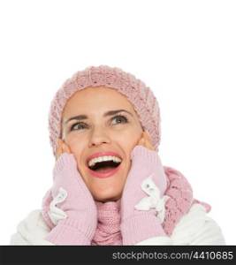 Surprised woman in knit winter clothing looking up on copy space