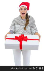 Surprised woman in Santa hat holding big Christmas present