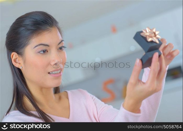 surprised woman looking on box with wedding ring