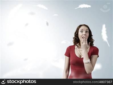 Surprised woman. Young emotional pretty woman in red dress