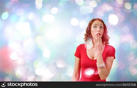 Surprised woman. Young pretty woman in red dress against bokeh background