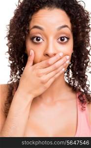 Surprised young african woman with hands over her mouth over white background