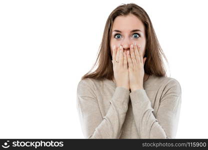 surprised young girl covers her mouth with her hands on a white background isolated