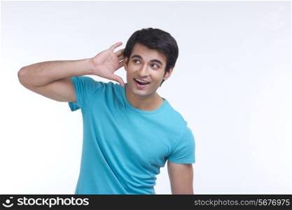 Surprised young man listening carefully isolated over white background