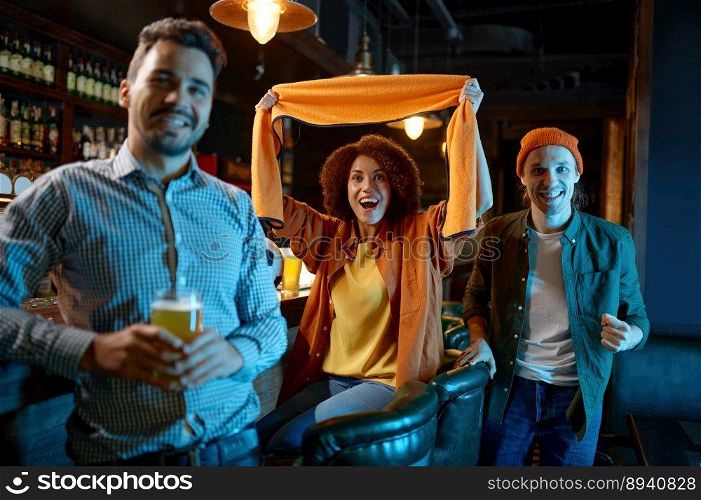 Surprised young people football fan cheering to support favorite team while watching soccer match on tv at sports bar. Focus on screaming woman holding scarf. Surprised young people football fan cheering to support favorite team
