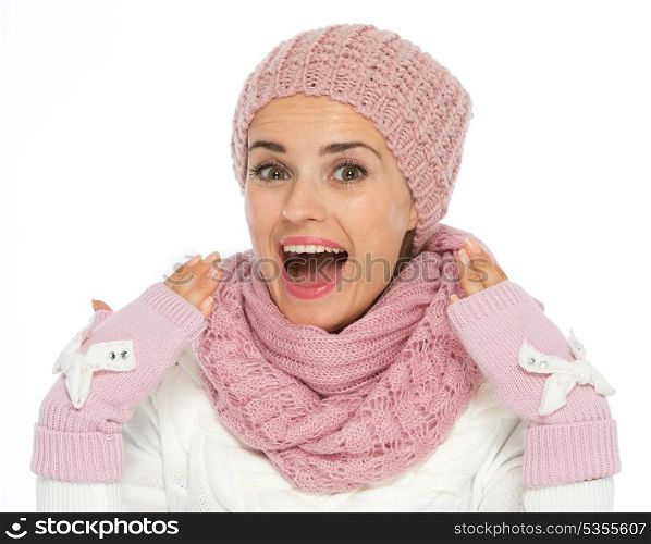 Surprised young woman in knit scarf, hat and mittens