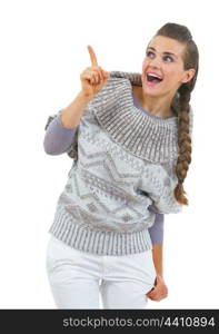 Surprised young woman in sweater pointing on copy space