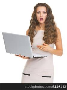 Surprised young woman pointing on laptop