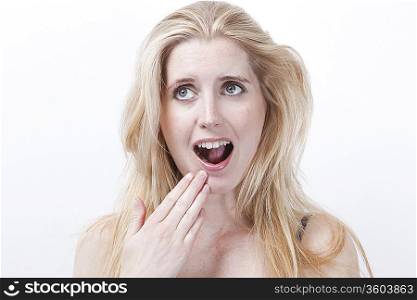 Surprised young woman with mouth open against white background