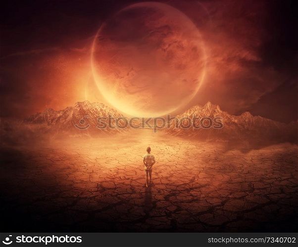 Surreal background as a young boy walks on another planet with dry and cracked ground, following a shining space object in the sky.