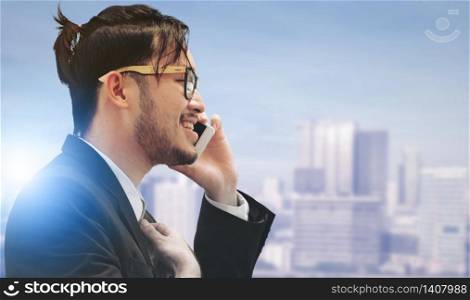 Surreal Image of Communication Concept - Young businessman using mobile phone with modern city buildings background. Future innovation technology and internet of things ( IOT ).. Surreal Image - Communication Technology Concept