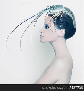 Surreal portrait of young lady with lobster on her head