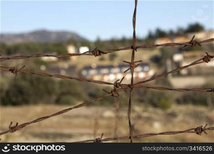 surrounded by rusted barbed wire fence of thorns