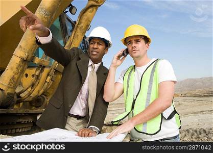 Surveyor and construction worker with blueprints