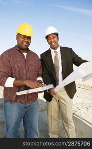 Surveyor and construction worker with blueprints, portrait