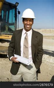Surveyor holding blueprints on construction site, portrait