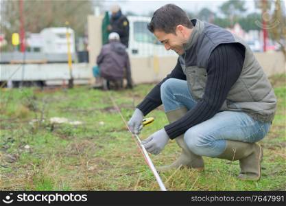 surveyor worker making measurement in the garden