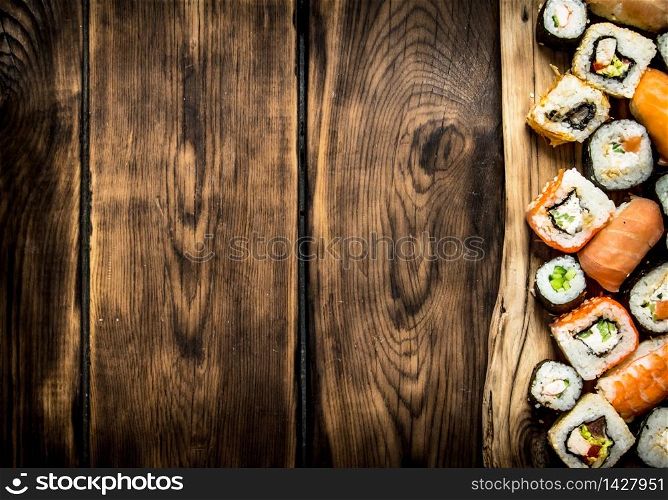 Sushi and rolls on the Board. On wooden background.. Sushi and rolls on the Board.