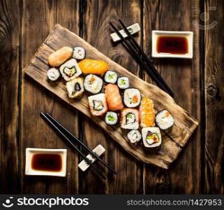 Sushi and rolls seafood with soy sauce. On wooden background.. Sushi and rolls seafood with soy sauce.