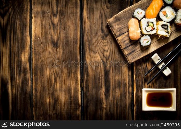 Sushi and rolls seafood with soy sauce. On wooden background.. Sushi and rolls seafood with soy sauce.