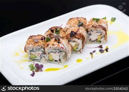sushi in a plate on a black background, close-up. fish roll. sushi on a dark background