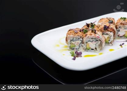 sushi in a plate on a black background with reflection. fish roll. sushi on a dark background