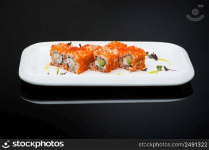 sushi in a plate on a black background with reflection. fish roll. sushi on a dark background