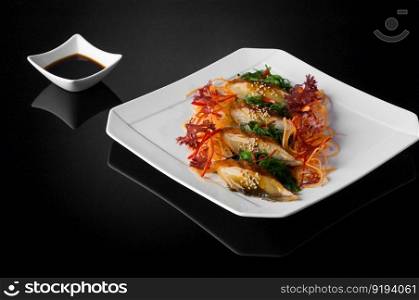 sushi in a white plate with sauce and soy on a black background with reflection. sushi in a plate on a black background