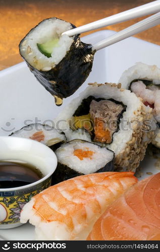 Sushi is a Japanese dish consisting of small balls or rolls of vinegar-flavoured cold rice served with a garnish of vegetables, egg, or raw seafood.