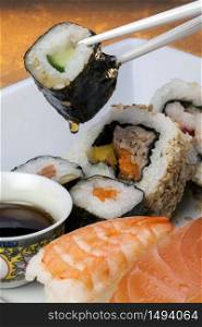 Sushi is a Japanese dish consisting of small balls or rolls of vinegar-flavoured cold rice served with a garnish of vegetables, egg, or raw seafood.