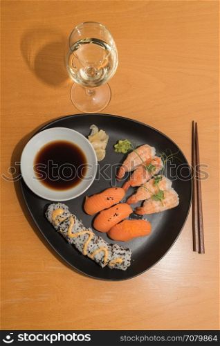 Sushi meal and white wine on a table, please enjoy your meal