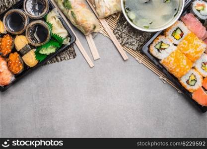 Sushi menu with summer rolls in rice paper wrappers and miso soup on gray on gray stone background, top view, border. Japanese and Asian food.