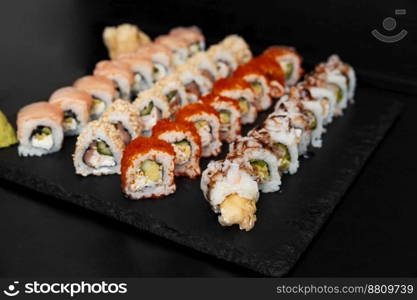 Sushi on a stone plate with black background