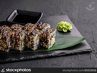 Sushi roll with fish, vegetables and cheese on black